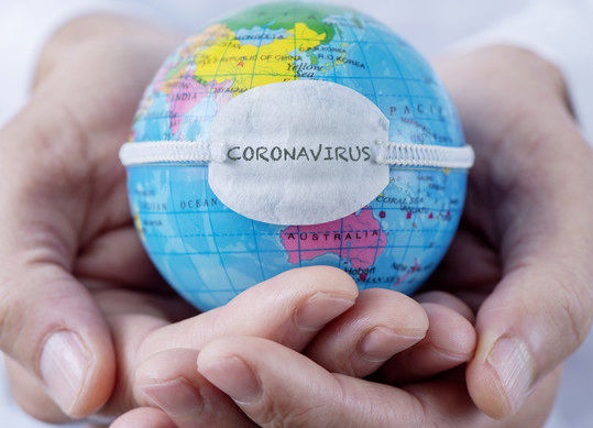 Coronavirus e decreti OMS il pianeta terra con la mascherina nelle mani di un adonna