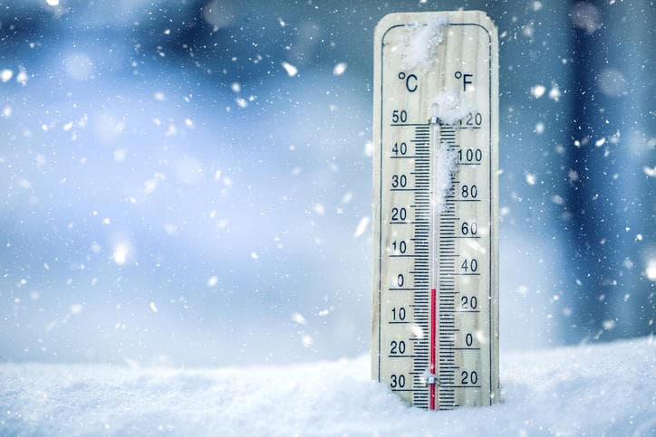fuori al freddo, nevica, c'è un termometro nella neve che segna una temperatura bassa