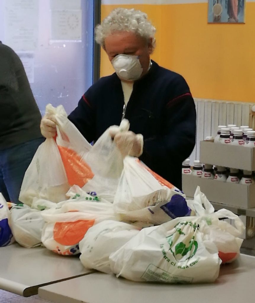 #lacaritànonsiferma mensa dei poveri don Adriano con mascherina sul viso prepara i pacchetti pasto per i poveri