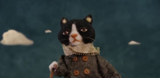 "Love Animals" di Alessandra Celletti. Un omaggio ai nostri amici a 4 zampe Un gatto vestito con un cappotto beige e la sciarpa al coll, cammina con unbastone in mano