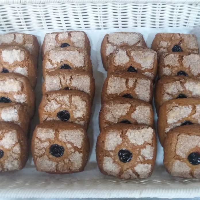 Il Rustico Ferdinando Tammetta una teglia piena di biscotti quadrati con al centro della marmellata di frutti di bosco