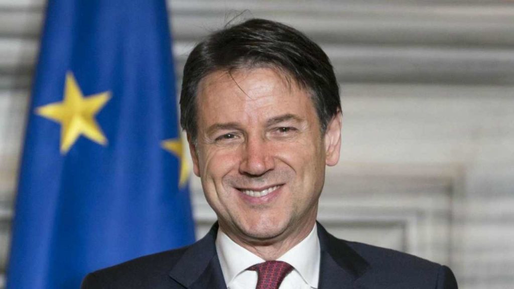 giuseppe conte sorridente con giacca scura e cravatta granata