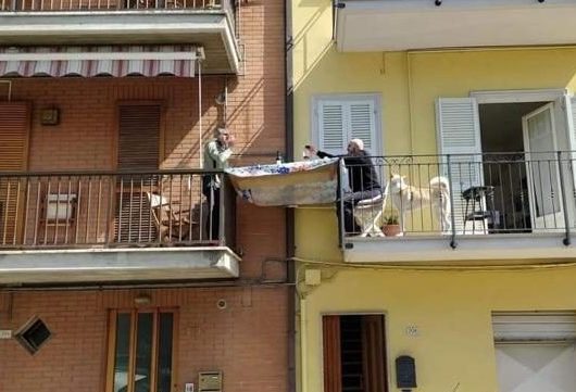 Pasqua alternativa a tombola e noci poi usciremo, salvo nuovo DPCM due persone hanno messo una tavola tra due balconi apparecchiata e mangiano ognuno dal proprio balcone ma insieme