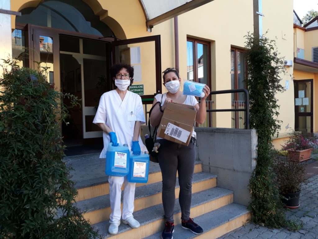 Rotary e covid-19 emergenza coronavirus due donne del personale sanitario di una struttura hanno in mano un cartone di mascherine e dei flaconi di disinfettanti davanti alla porta di una struttura ospedaliera