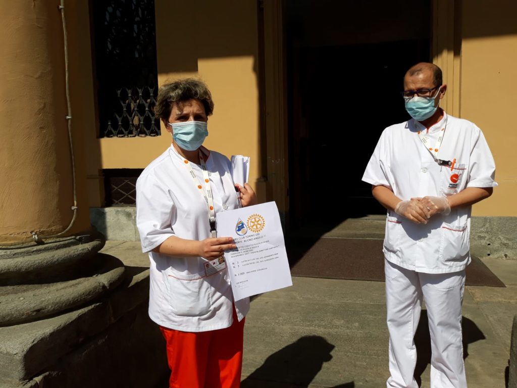 Rotary e covid-19 emergenza coronavirus due persone del personale sanitario di una struttura hanno in mano un cartone di mascherine e dei flaconi di disinfettanti davanti alla porta di una struttura ospedaliera