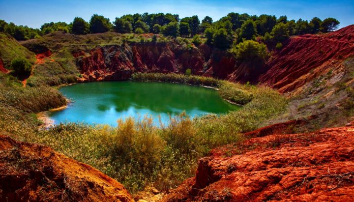 La Cava di Bauxite nel Salento. Il lago è circondato da alberi e terra rossa