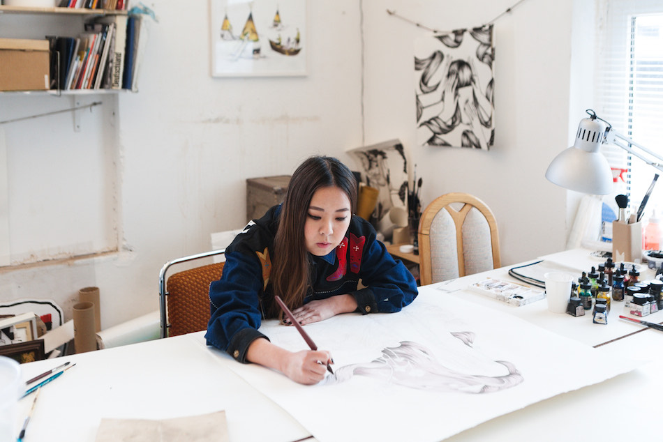 Color4action Andrea Wan street artist seduta al avolo da disegno mentre lavora