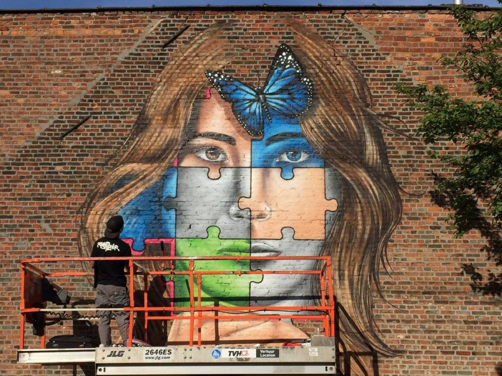 Color4action MrKas una street artist mentre è su un'impalcatura a disegnare su un muro
