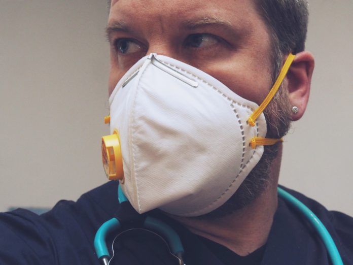 Ripartenza fine maggio: virologi - nella foto un uomo sul lavoro con la mascherina bianca