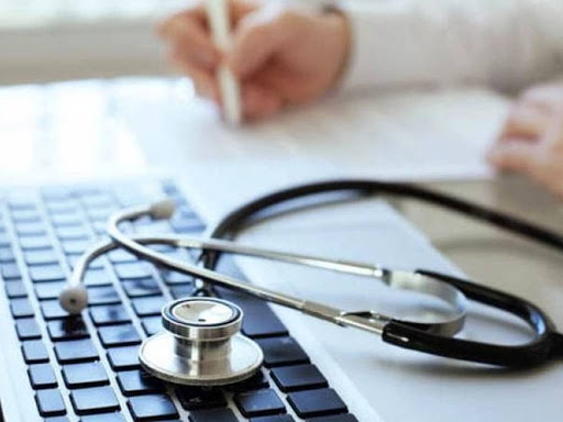 Stetoscopio per medico di base appoggiato sul computer