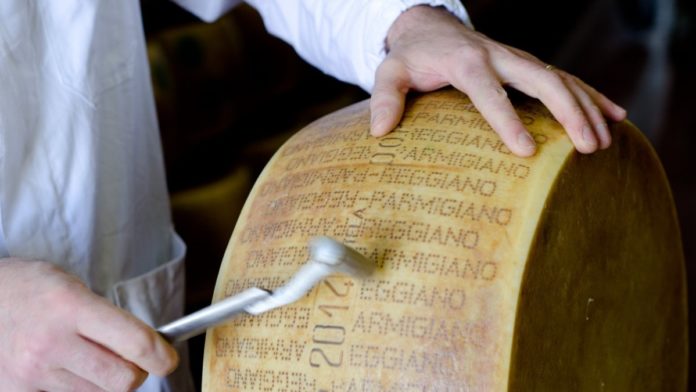 Dazi un uomo sta martellando una forma di parmigiano