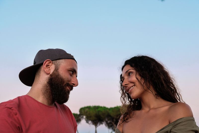 Luvespone feat tarsia. sfondo azzurro e alberi, in primo piano i due cantanti. A siinistra lui, con barba, maglietta rossa e berretto con visiera rovesciata, a destra lei, capelli lunghi e ricci, vestito scollato. Entrambi sorridono e si guardano.