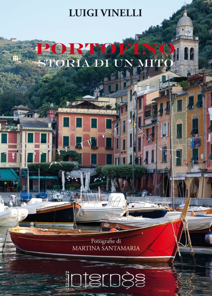 Portofino storia di un mito la copertina del libro di Luigi Vinelli\  con il borgo del paese sullo sfondo e davanti, una barca rossa sul mare