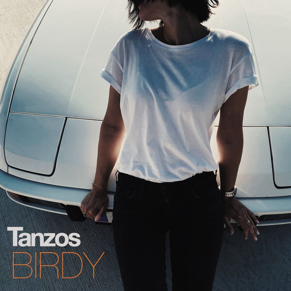 birdy tanzos - La copertina del singolo che ritrae una donna, jeans e maglietta bianca, appoggiata al cofano di un'automobile