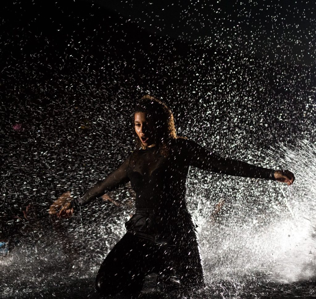 brenda carolina lawrence soy maria - nella foto la cantante vestita di nero davanti al gioco d'acqua di una fontana, di notte al buio