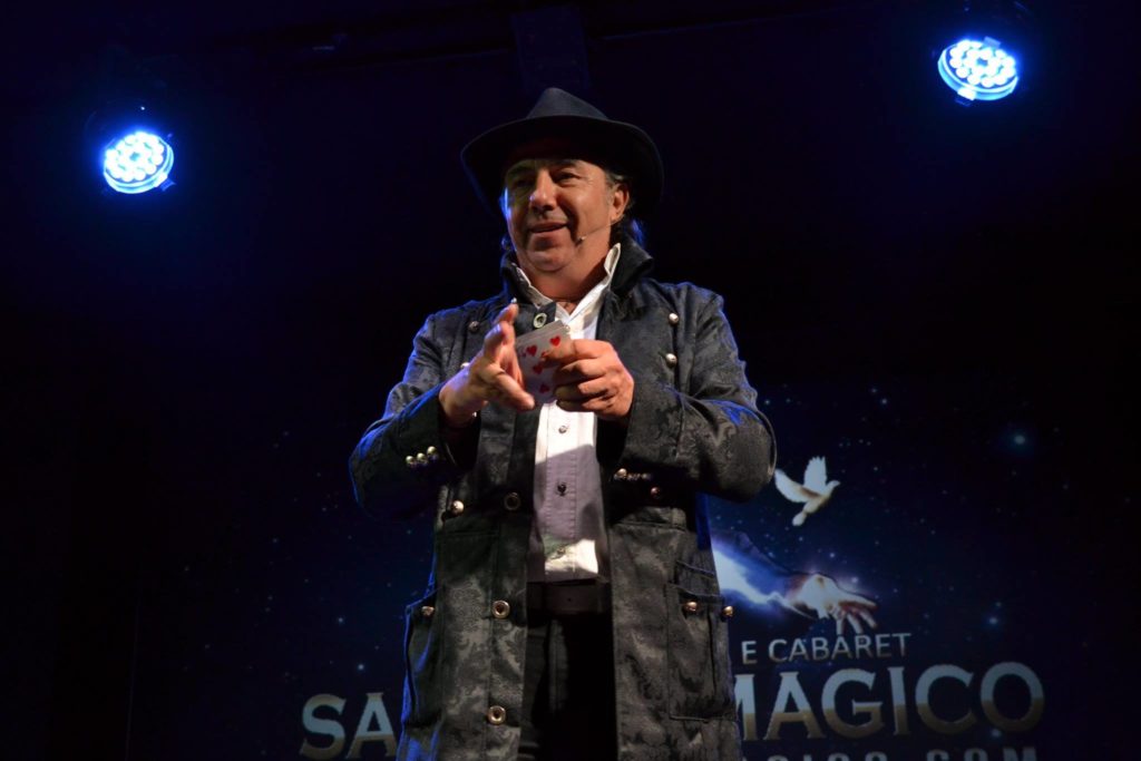 #CabaretShow - Walter Perino con cappello e giacca con un mazzo di carte in mano durante uno spettacolo di magia