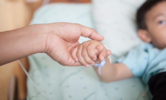 Trip to Trieste - Una mano tiene la mano di un bambino ricoverato in ospedale