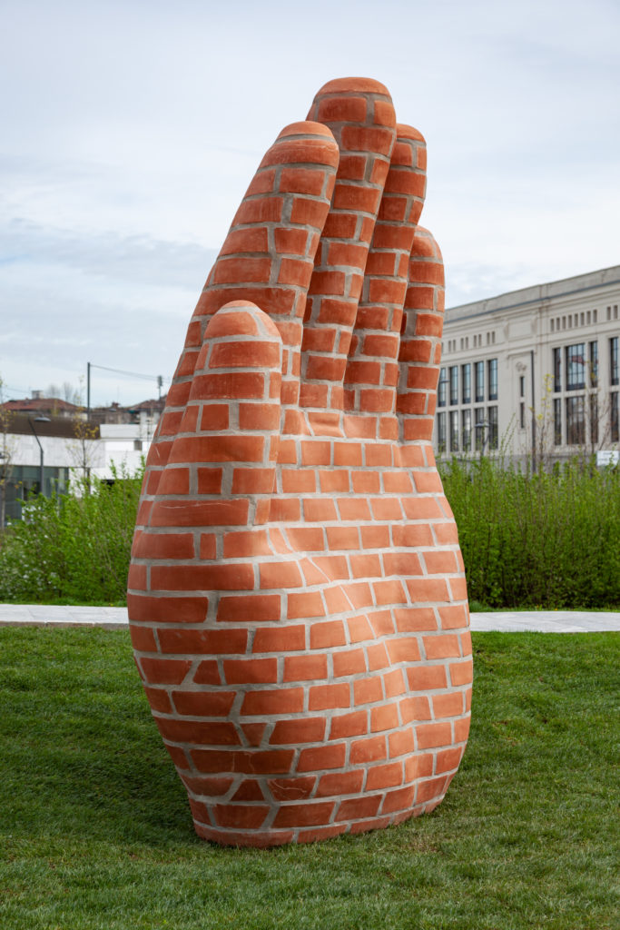 Milano ArtWeek una scultura rappresentante una mano gigantesca aperta, disegnata con mattoni rossi
