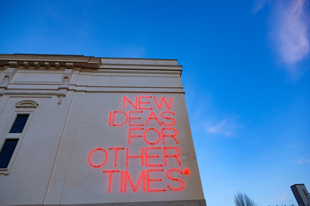 Un edificio con la scritta rossa "New ideas for other times"