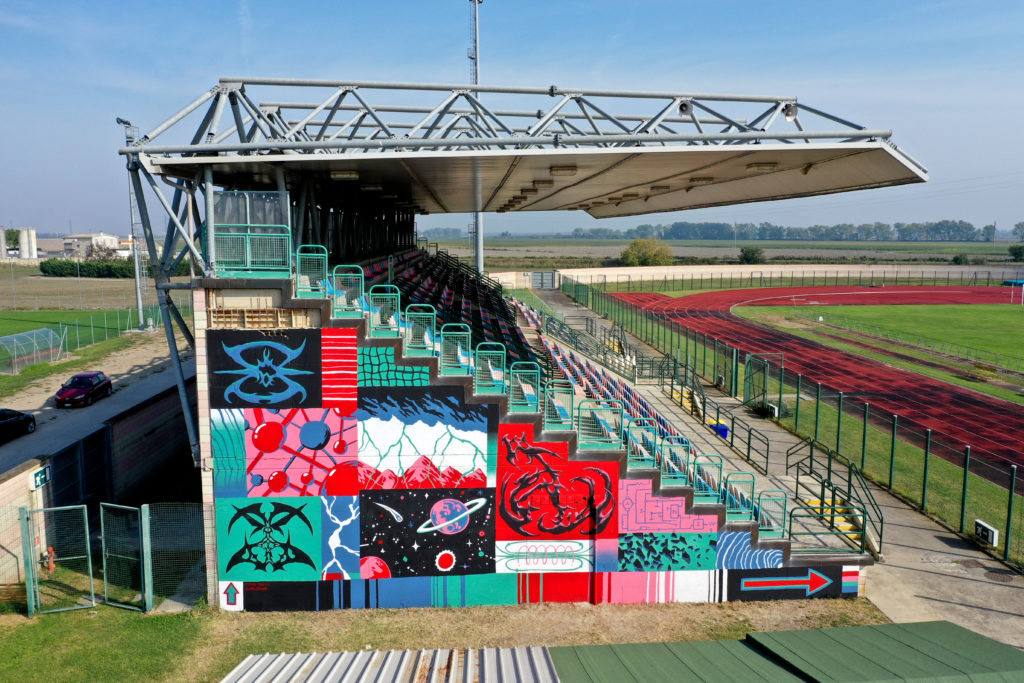 Stadio di Comacchio - la parete delle gradinate colorata con disegni di street art