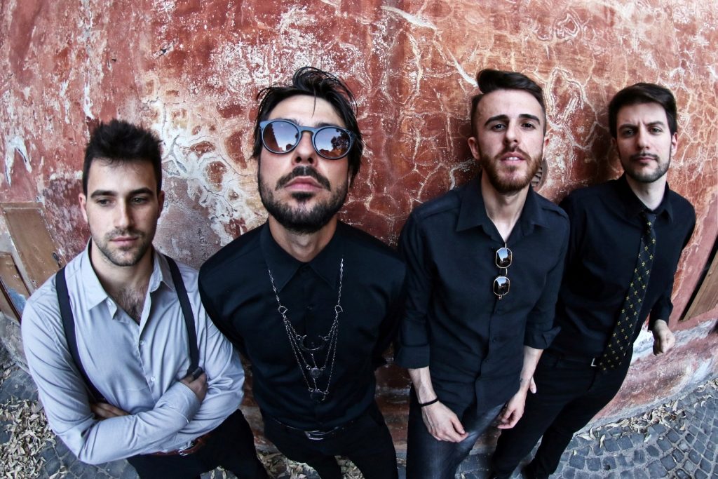 NDM indieota - nella foto i quattro ragazzi della band, appoggiati a un muro di mattoni rossi