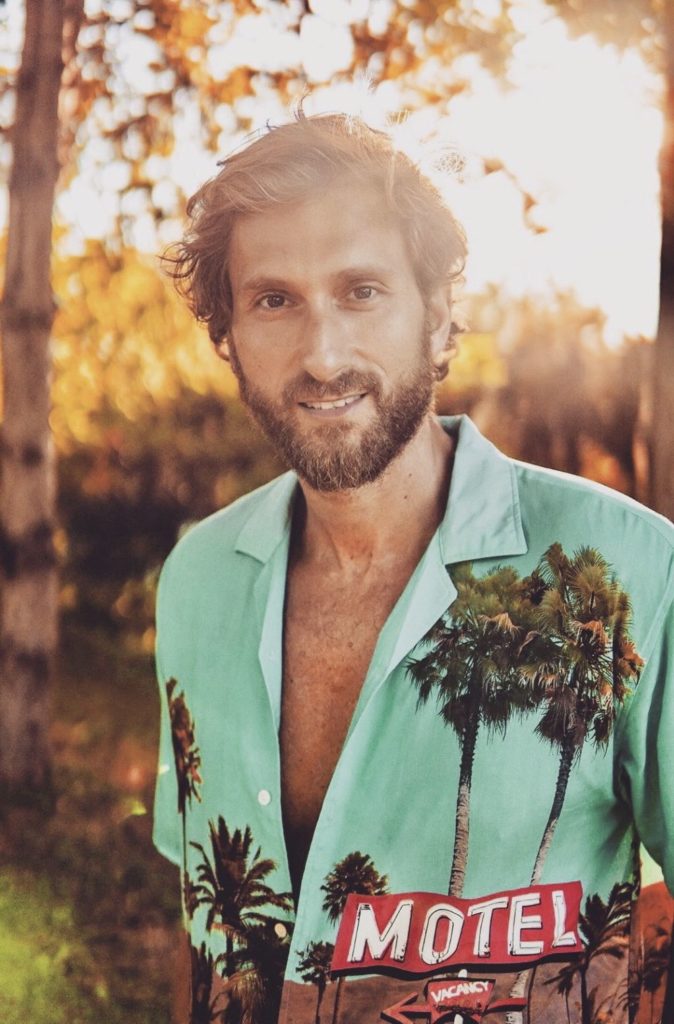 nicolas bonazzi - solo cose belle - primo piano del cantautore, barba e capelli rossicci, che indossa una camicia azzurra con palme disegnate