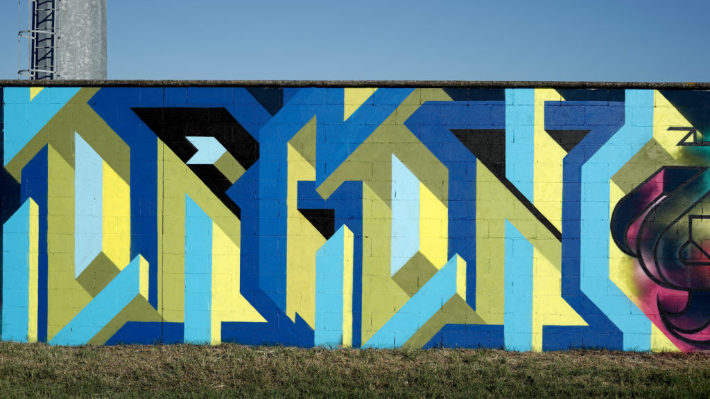 Manufactory Prject - un murales scritta in blu e giallo