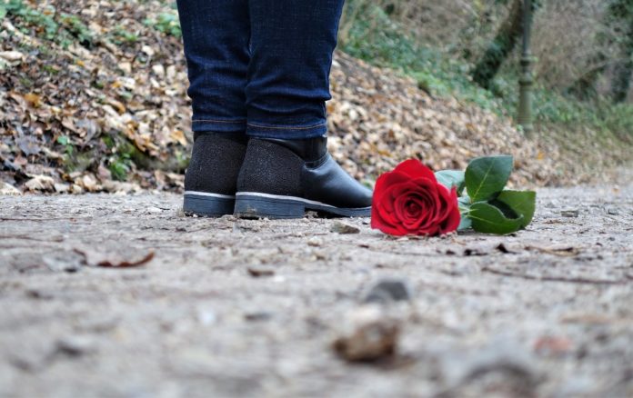 Challenge mortali pippo umano - una rosa rossa vicino adue piedi di bambino su un sentiero ciottolato
