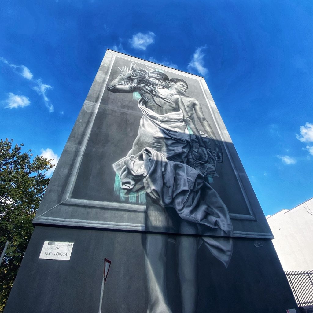 Outside In il pmurale dedicato a LGBT con due corpi di donna e di uomo che si abbracciano avvolti da un lenzuolo