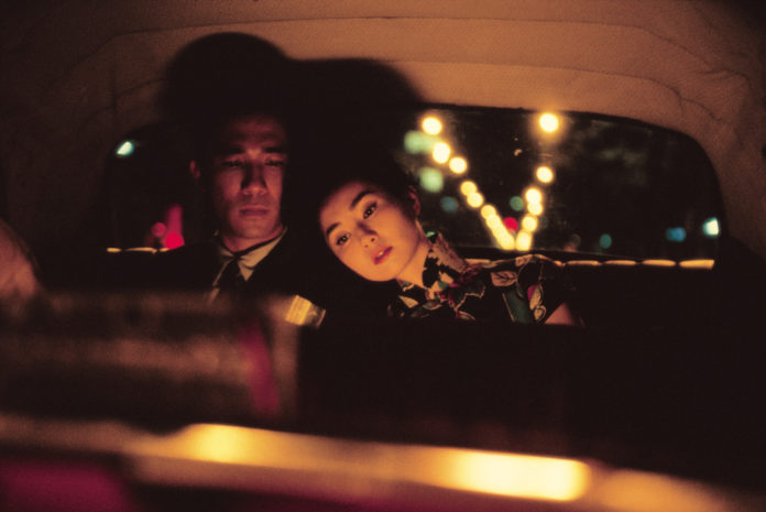 Amore ed eros nel film asiatico the mood for love, i due protagonisti sono seduti sul sedile posteriore di un'auto e la ragazza ha appoggiato la testa sulla spalla di lui