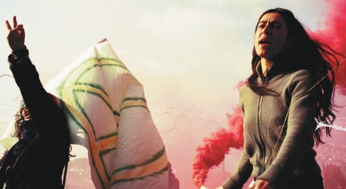 il cinema dei movimenti - la locandina con due donne impegnate in una manifestazione politica con una bandiera bianca con il simbolo dell'anarchia