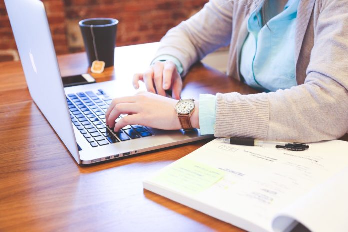 bonus internet - una ragazza davanti a un pc portatile con una tazza di tè affianco