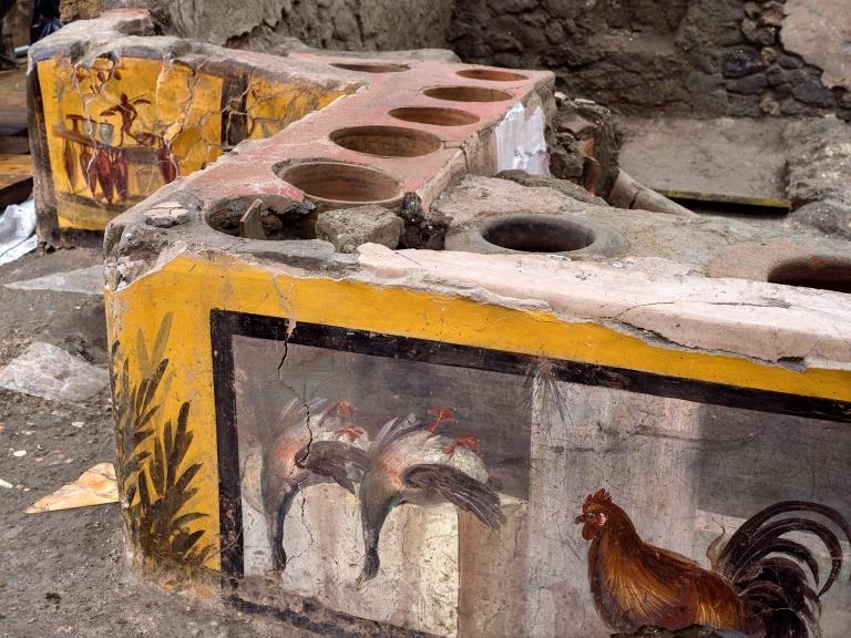 streetfood e lounge bar - un bancone di pietra con affreschi sui lati e dei recipienti scavati nella pietra del bancone