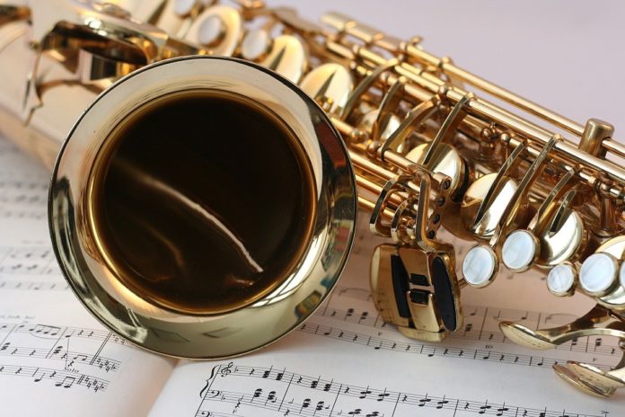 museo del saxofono - nella foto il logo del museo con un sassofono su sfondo di pagine di un pentaagramma musicale
