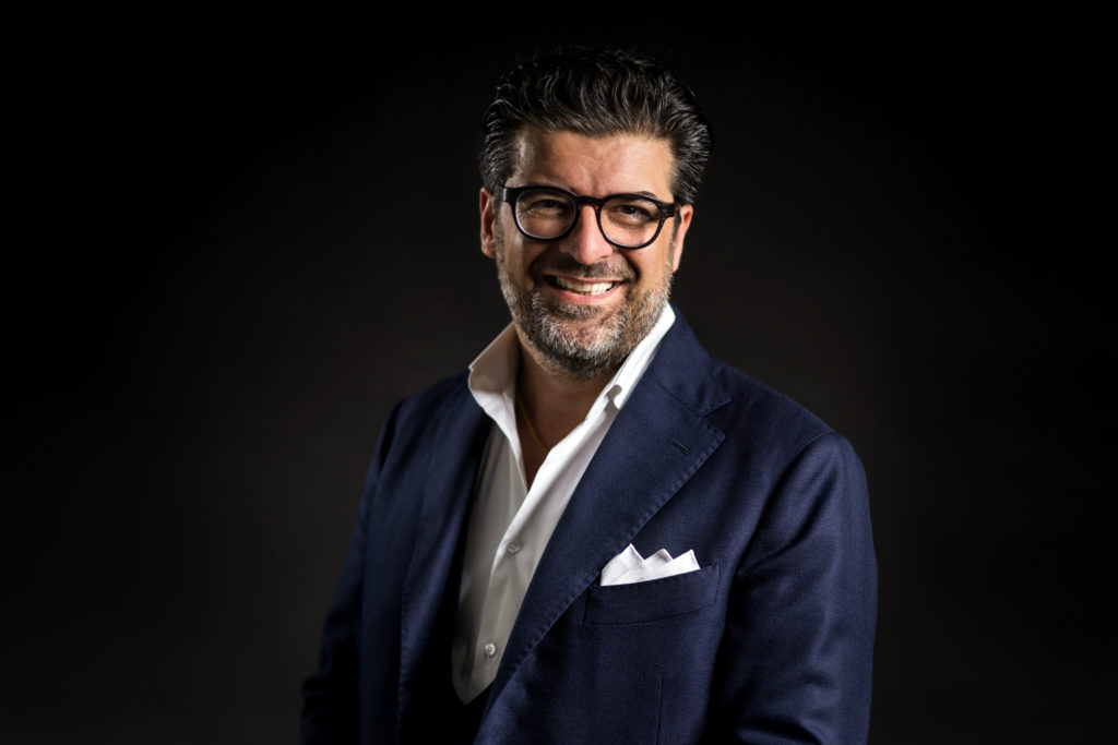 Premio "l'Italia che Comunica 2020" - nella foto Claudio Capovilla con occhiali da vista neri giacca con fazzolettino bianco nel taschino, camicia bianca aperta e l'uomo sorride felice