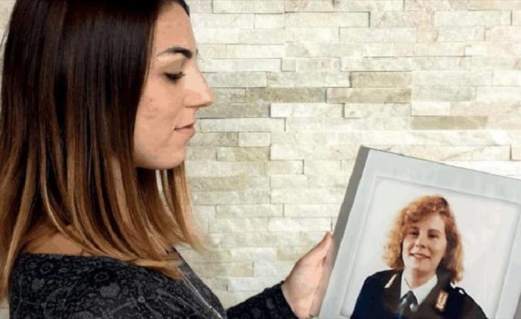 Emanuela Loi in Polizia - nella foto con capelli lunghi scuri tiene inmano una fotografia della zia poliziotta