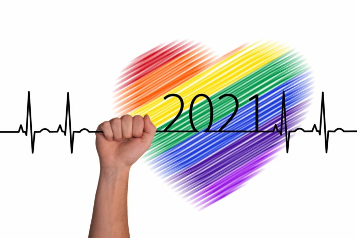 Un cuore disegnato con i colori dell'arcobaleno e un tracciato di elettrocardiogramma con la scritta 