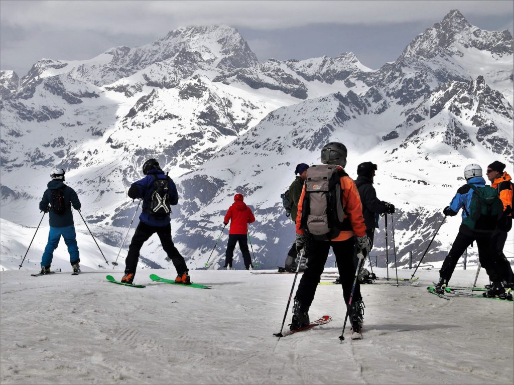 degli sciatori su una pista di sci piena di neve