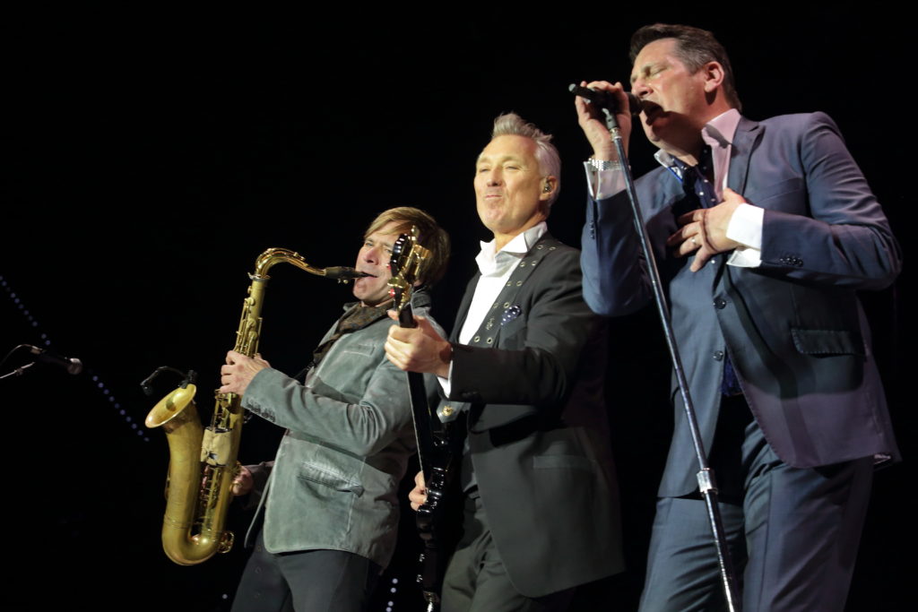 spandau ballet: steve col sax, gary con la chitarra e Tony col microfono in mano, in un momento del concerto.