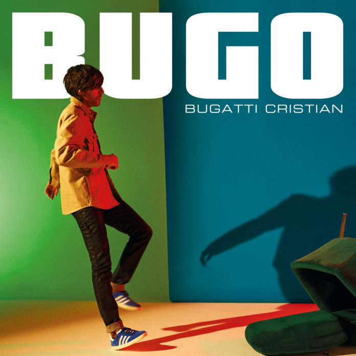 in foto la copertina del disco di Bugo. il cantante è in piedi che cammina da sinistra a destra, con una giacca gialla, pantaloni neri, dietro la scritta Bugo e il nome dell'album Bugatti Cristian. il pavimento dove cammina è arancione, lo sfondo a metà verde e azzurro