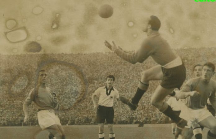 Sportmemory - una fotografia in bianco e nero ingiallita dal tempo ritrae una partita di calcio tra Italia e Germania Ovest con dei giocatori e in mezzo a loro un giocatore che salta per calciare il pallone