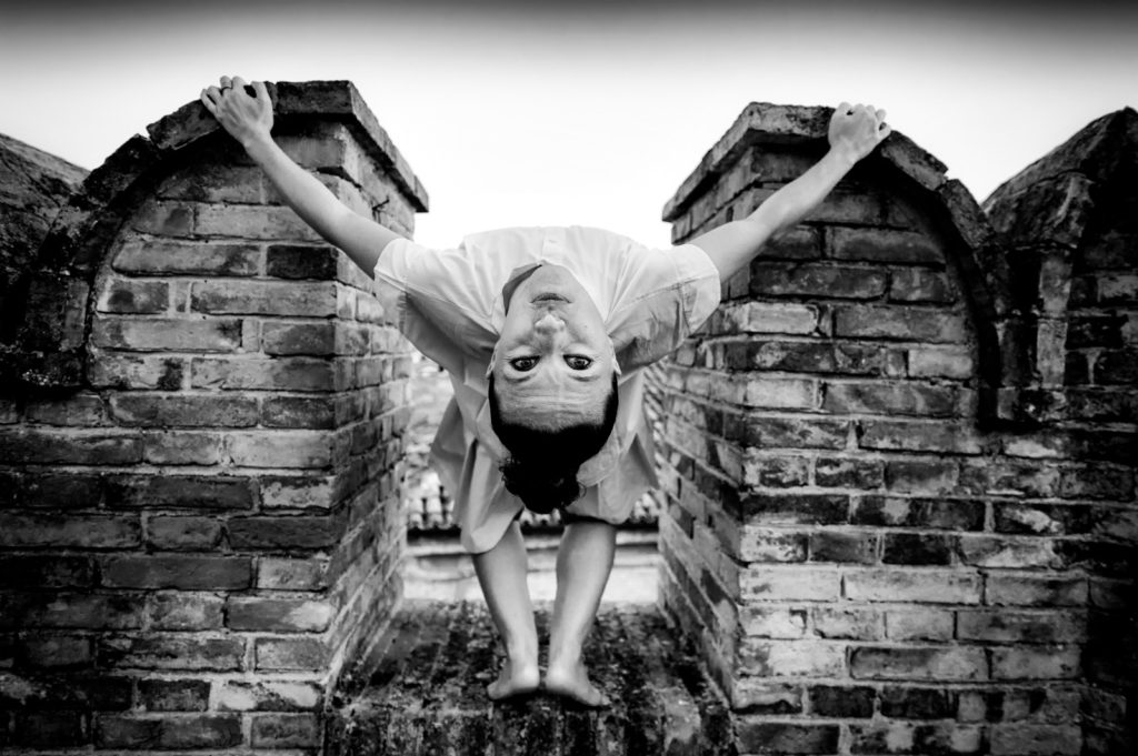 Danza al Teatro Goldoni , una ballerina si tiene a due pilastri di un muretto e si curva con la schiena all'indietro e guarda l obiettivo. la foto in bianco e nero