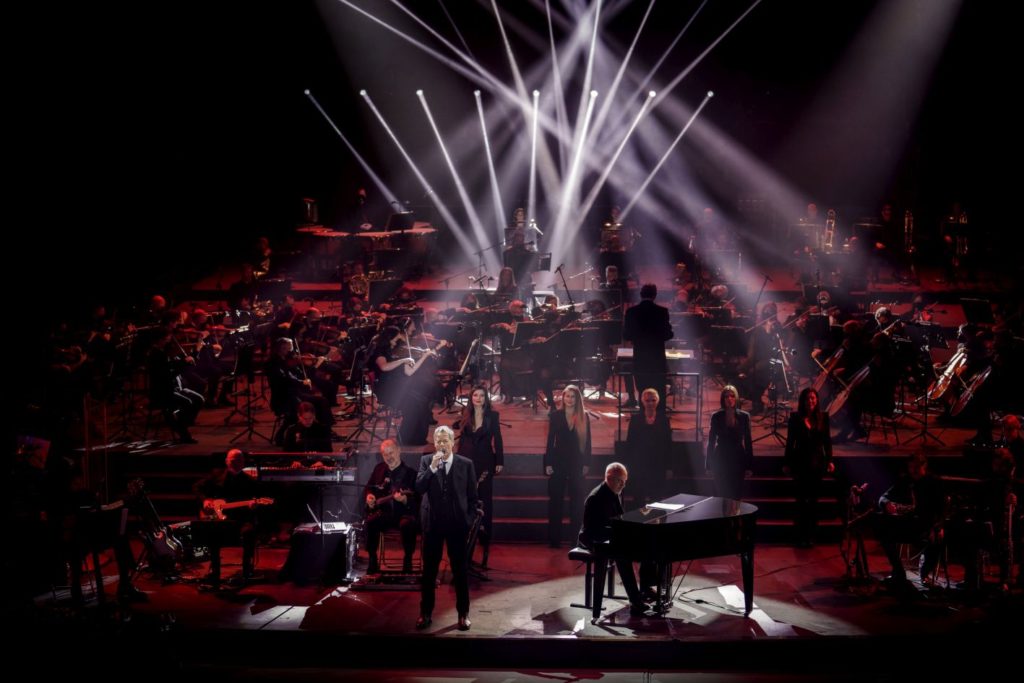 Claudio Baglioni durante le prove dello spettacolo con tanti ballerini con le luci viola