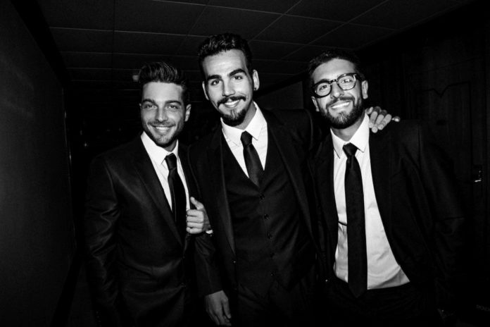 copridfuoco concerto il volo - nella foto in bianco e nero i tre ragazzi del gruppo sono vestiti con giacca e cravatta e camicia bianca. Sorridono abbracciandosi