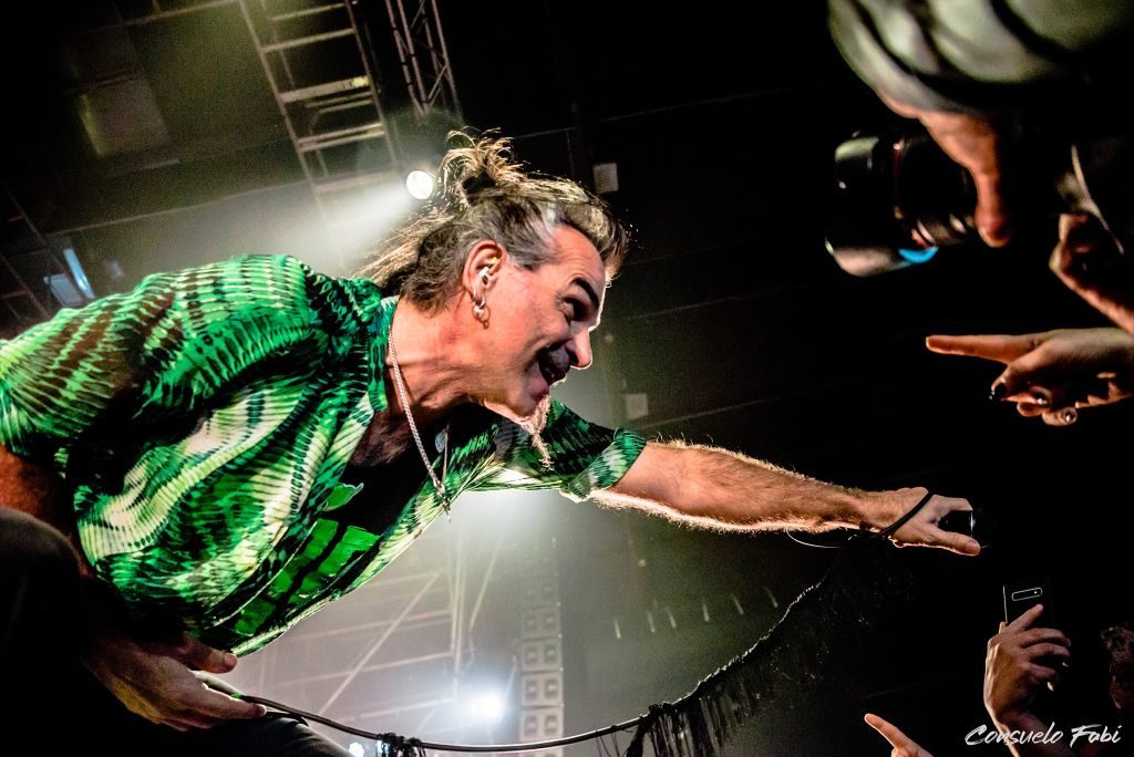 - Piero Pelù in concerto con camicia verde da la mano ad un fans,