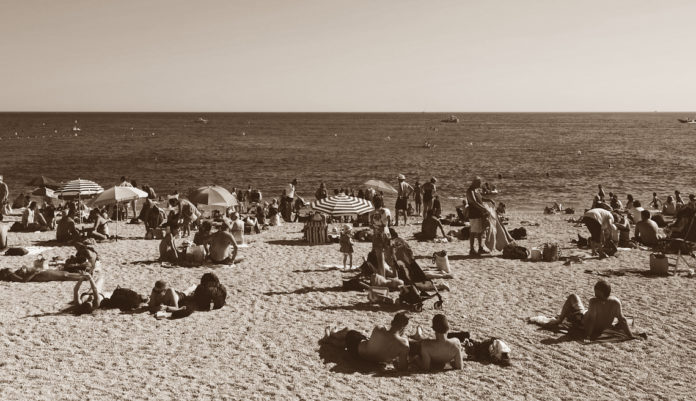 anni '60 - una spiaggia dell'epoca affollata di bagnanti
