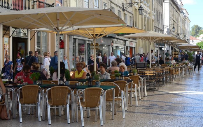 da oggi coprifuoco - della gente seduta ai tavoli dei dehor dei bar e ristoranti in un avia del centro