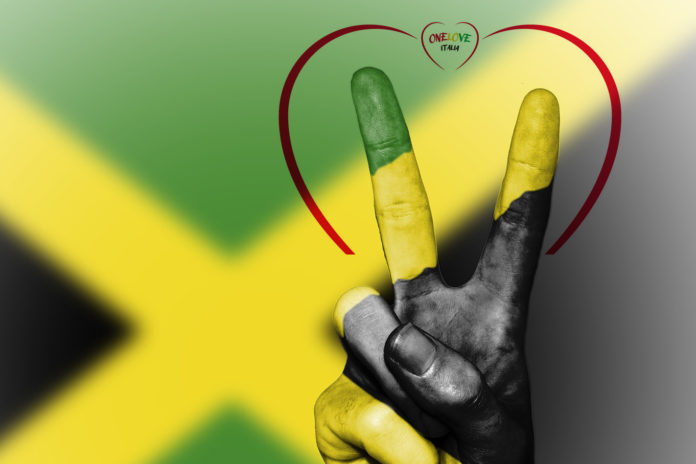 One Love Reggae Reunion sullo sfondo la banfdiera giamaicana fatta con una 