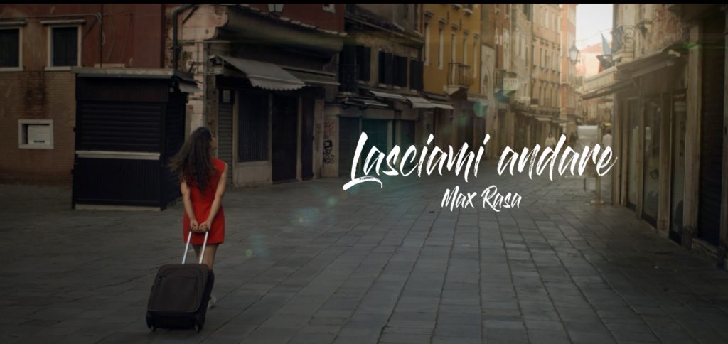 lasciami andare - la copertina del singolo che ritrae una donna di spalle, vestita di rosso, con un trolley, a passeggio per le vie di venezia