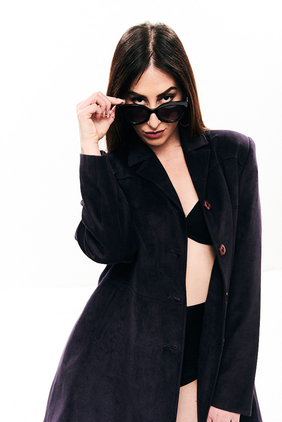 crazy - la ciotta in una posa sexy, indossa un cappotto nero, occhiali da sole